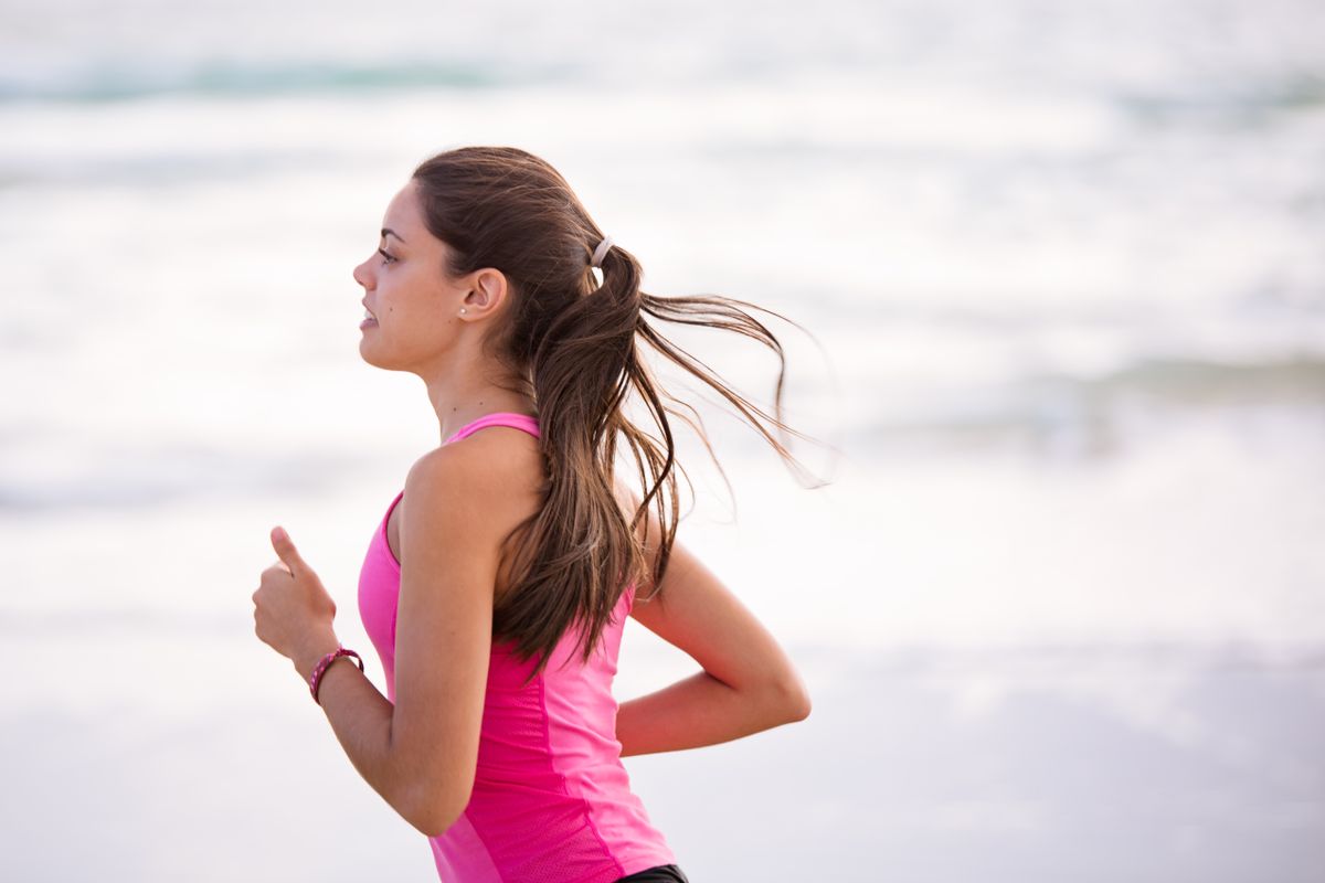 A healthy, active person jogging freely outdoors without pain